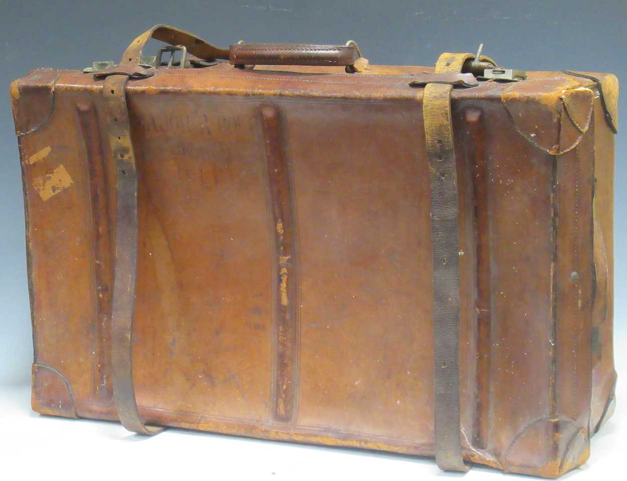 An early 20th century leather strapped suitcase locks by USA indistinctly stamped on the outside