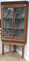 An early 19th century pine corner cupboard on modern stand, fitted with a pair of spandrel glazed