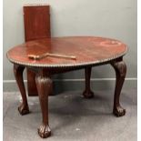 A Edwardian mahogany oval extending dining table with single leaf and winder on claw-and-ball feet