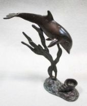 A bronze candle holder cast as a dolphin,