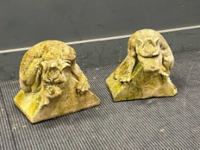 A pair of weathered cast stone gate post finials in the form of crouching gargoyles 27 x 29 x 28cm