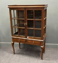 An Edwardian oak glazed cabinet on associated stand, two drawer base with scalloped frieze on