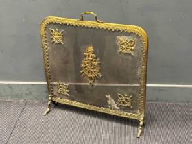 An early 20th century gilt metal fire guard decorated with five metal mounts of garlands and torches