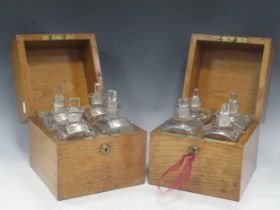 A pair of oak decanter boxes, each fitted with four glass decanters with spirit labels