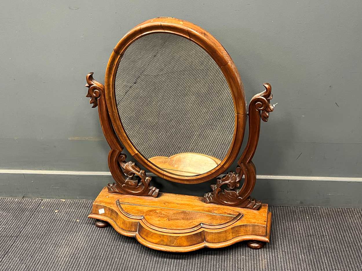 A Victorian mahogany swing mirror, the oval plate above a shaped base 83 x 72 x 28cm