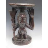 A Luba Hemba carved stool, the circular top supported by a male and a female figure 43 x 32 x 29cm
