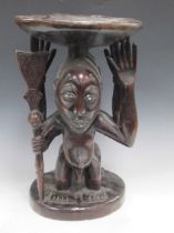 A Luba Hemba carved stool, the circular top supported by a male and a female figure 43 x 32 x 29cm