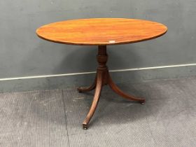 An early 19th century mahogany occasional table with oval tilt-top on a turned column on splayed