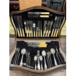 A wooden canteen containing a selection of silverplated flatware