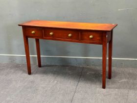 A modern cherry wood console table with three drawers on tapered legs 76x 129.5 x 36cm