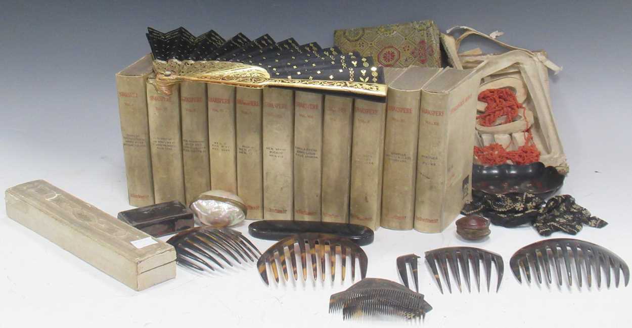 A collection of objects including a fan, tortoiseshell combs, spectacle case, snuff box, coral