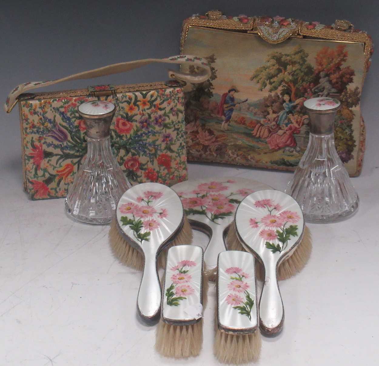 A silver and floral enamelled dressing table set, two silver topped lass scent bottles, a floral