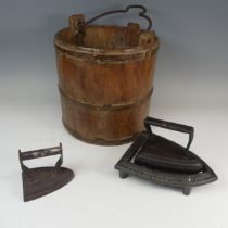 An antique oak iron-bound Bucket, W 32 cm x H 35.5 cm x D 32 cm, together with two irons and a