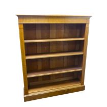 An Edwardian light oak open Bookcase, with four adjustable shelves flanked by pilasters on plinth