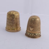 A 9ct gold Thimble, with foliate engraved decoration, 20mm high, together with another unmarked in