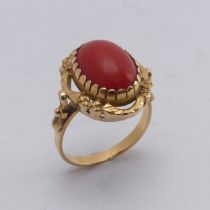 A coral Dress Ring, the oval cabochon stone approx. 14mm long, mounted in 18ct yellow gold, Size N½,