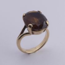 A smoky quartz Dress Ring, the oval facetted stone 16mm long, four claw set in unmarked gold, tested