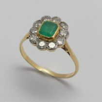 An emerald and diamond cluster Ring, the central emerald approx. 5x4.5mm collet set in yellow gold