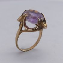 An amethyst Dress Ring, the pale oval facetted stone approx. 14mm long, in scrolling 9ct gold mount,