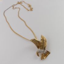 A 9ct yellow and white gold Eagle Pendant, the body set with diamond points, 2.3cm long, on a 9ct