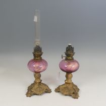 A pair of French late 19th century Oil Lamps, made by 'Gaudard', cranberry glass reservoirs raised