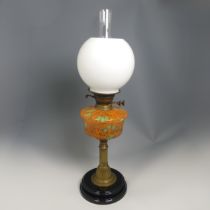 An antique brass Oil Lamp, painted bohemian glass reservoir raised on brass base, stamped 'British