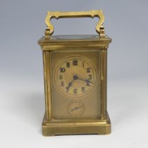 An early 20th century French brass alarm carriage Clock, gilt arabic dial above subsidiary arabic