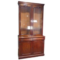 A Victorian mahogany glazed Bookcase, moulded cornice above two large glazed doors with carved