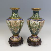 A pair of 20thC Japanese cloisonne Vases, decorated with floral patterns and raised on carved