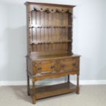 A Carolean style oak Dresser, moulded cornice over pierced frieze and two shelves, above two moulded