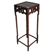 An antique Chinese hardwood Plant Stand, square top above carved foliate frieze, raised on bamboo