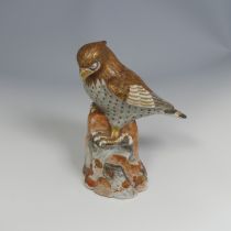 A 19thC Japanese kutani porcelain sculpture of a Bird of Prey, decorated in the typical palette, six