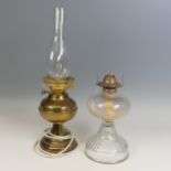 An antique clear glass Oil Lamp, H 27 cm, together with a brass Oil lamp, which has been
