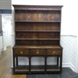 A George III oak Dresser with plate rack, moulded cornice over frieze with hooks, above three