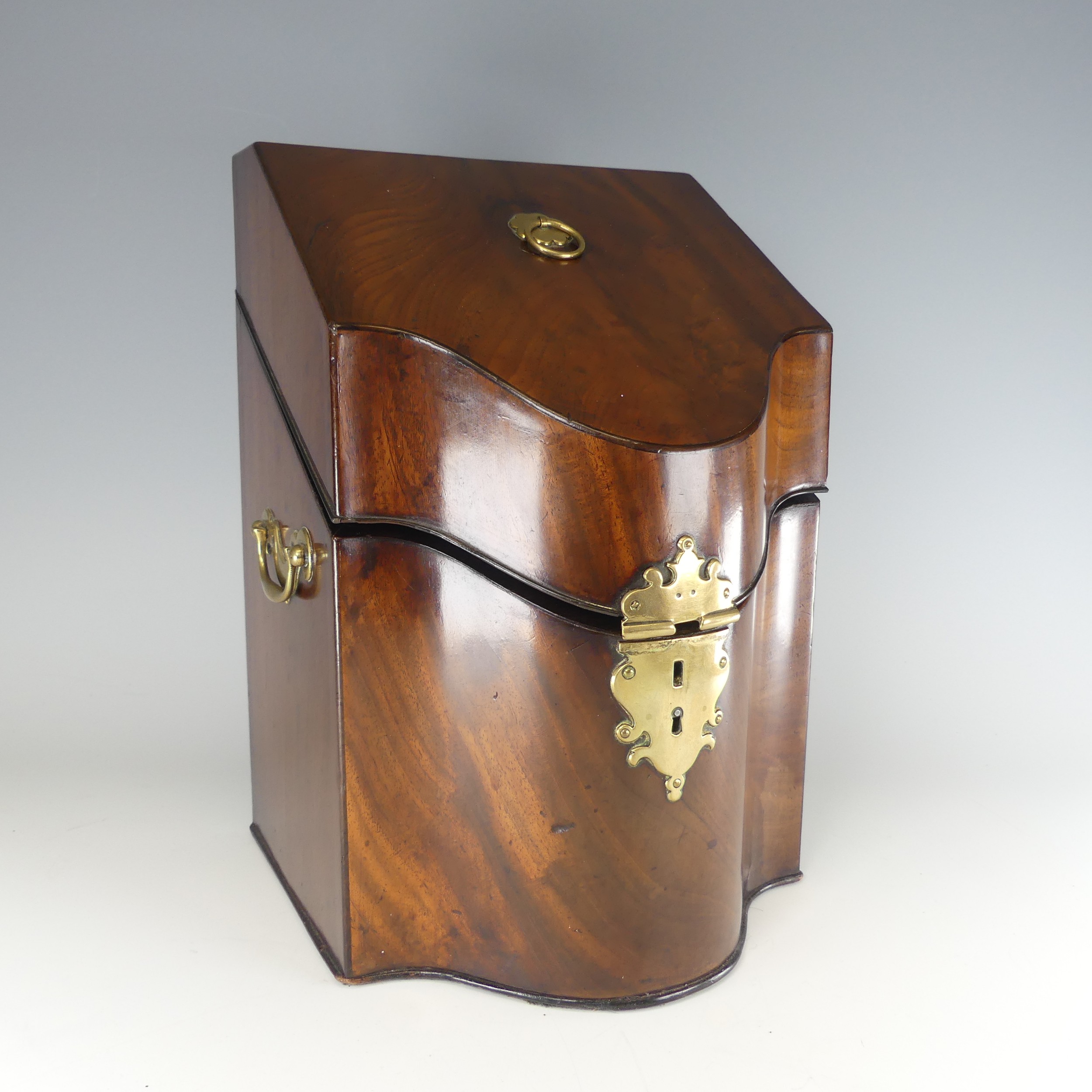 A Georgian mahogany serpentine front Knife Box, brass carrying handles to either side, with original