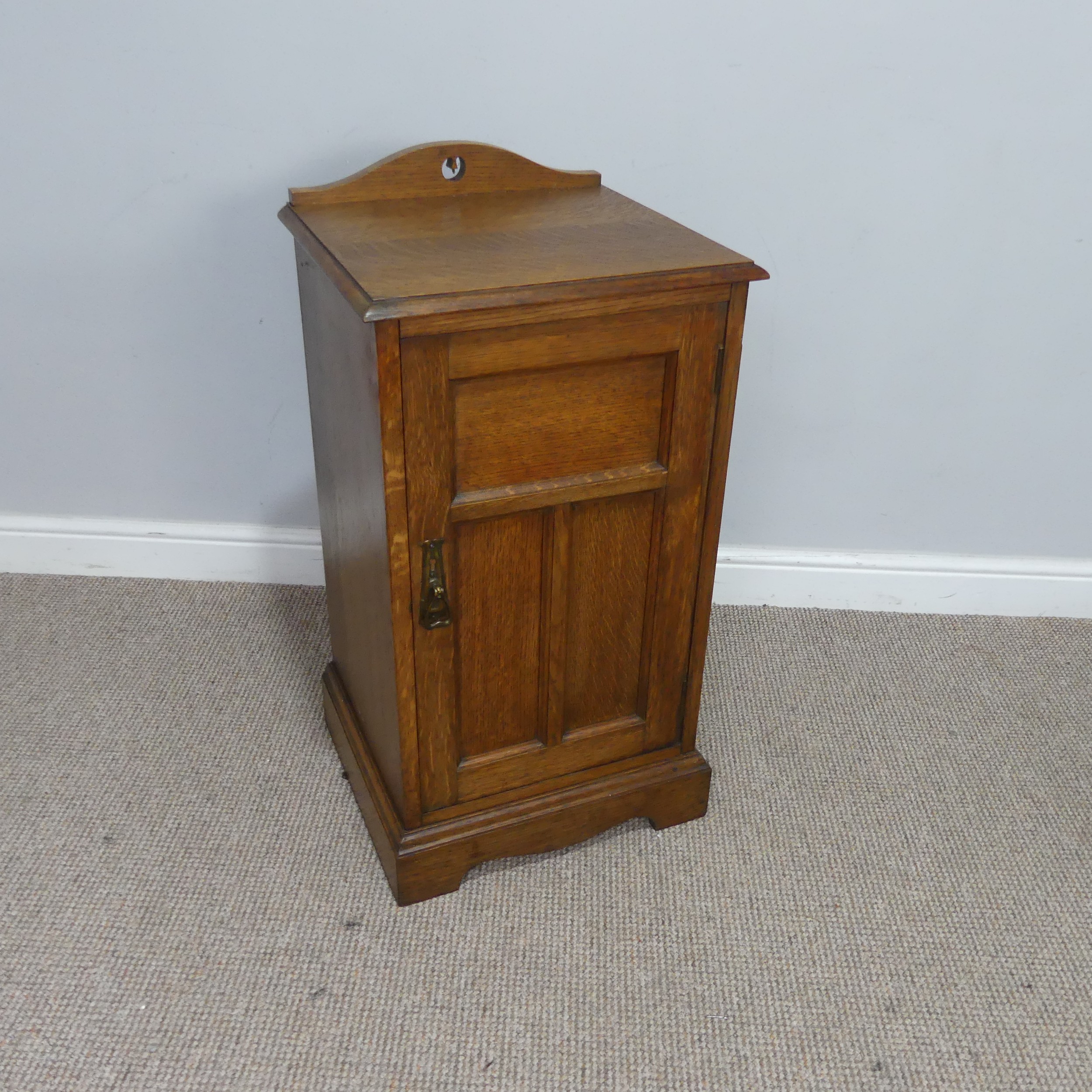 An Arts and crafts oak bedside Cabinet, pierced top over panelled doors, raised on shaped plinth - Image 2 of 3