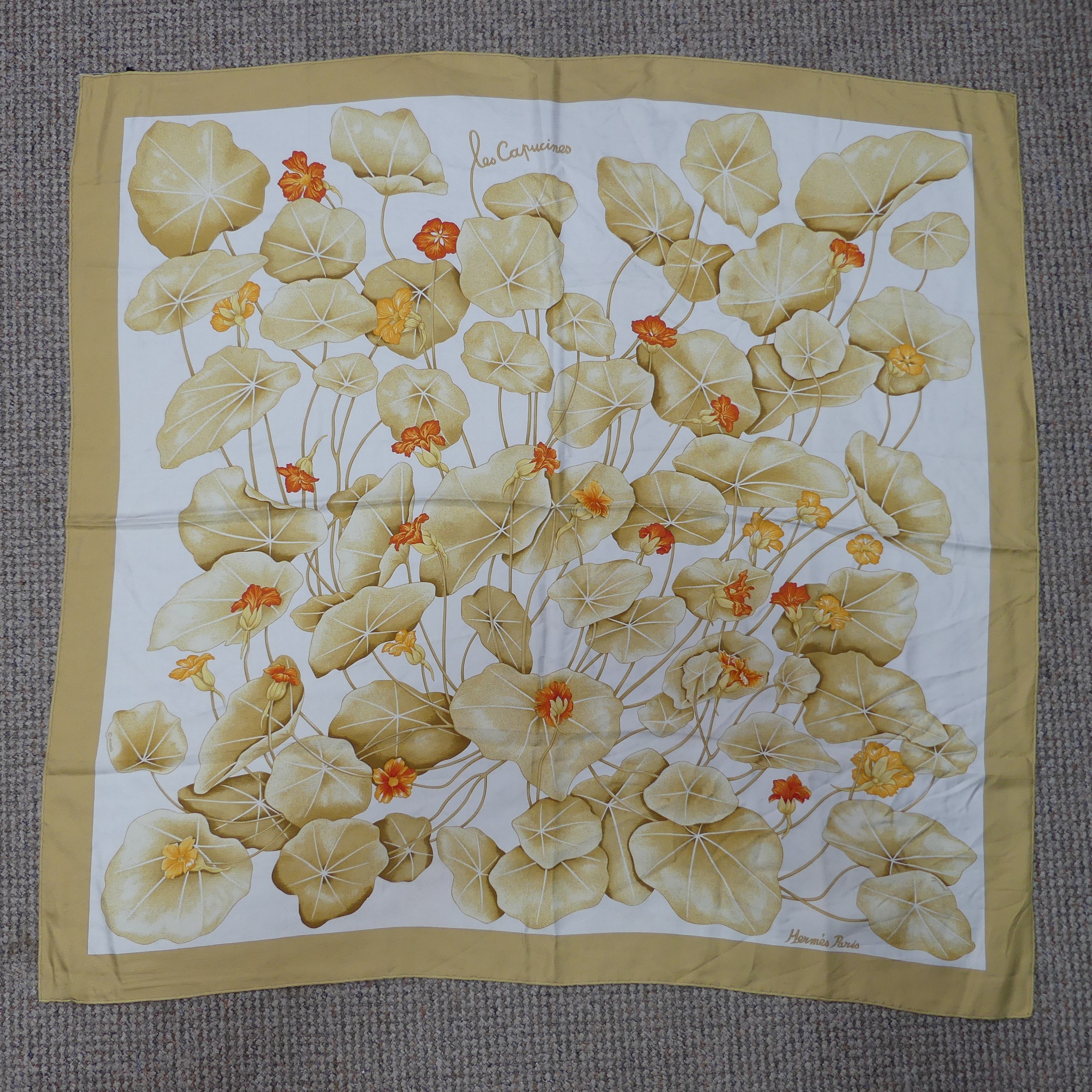 Three Hermès silk twill scarves: 'Les Capucines', orange and gold on cream background, Crown or