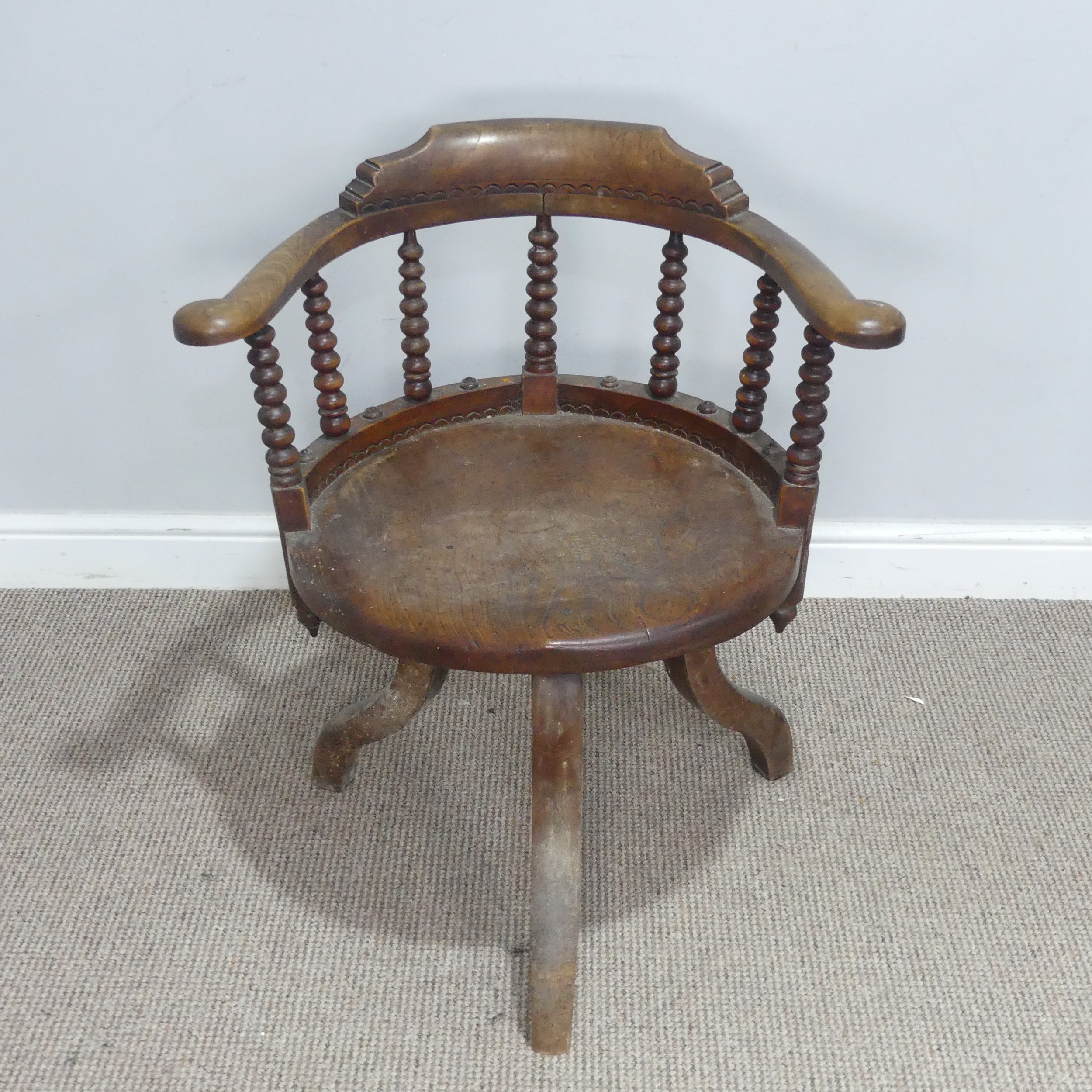 A late 19th century ash and elm Smokers elbow swivel desk Chair, turned column back rests, over