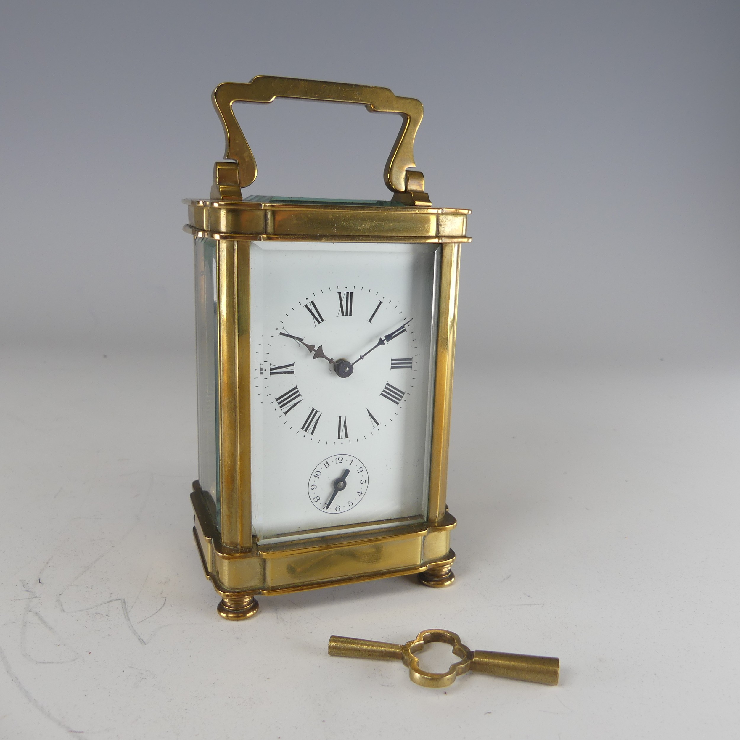 A 20th century French alarm carriage Clock, enamelled white dial with Roman numerals and