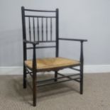 In the manner of William Morris, an antique ebonised Sussex Chair, with turned bobbin back and