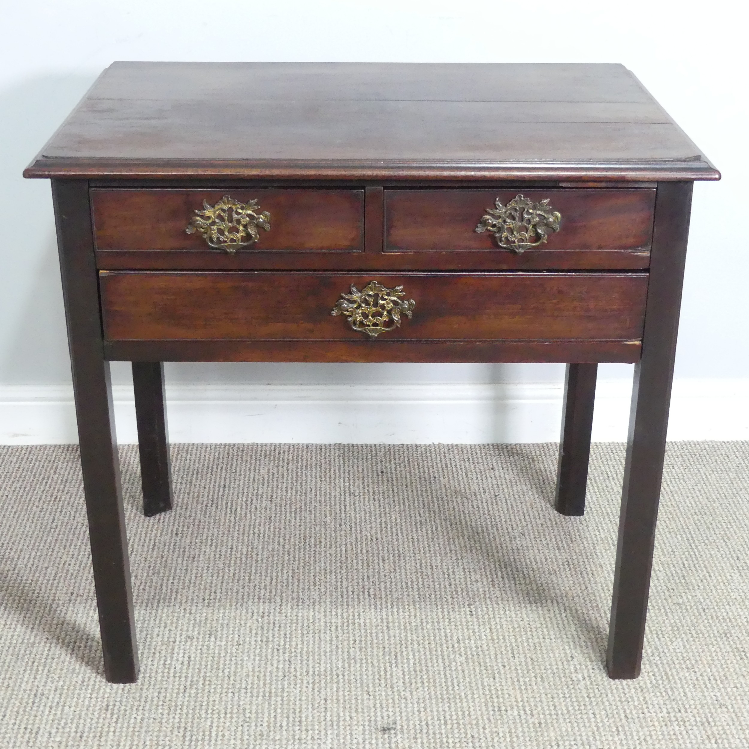 A Georgian oak Lowboy, shaped top over three drawers and square canted legs, W 75.5 cm x H 71 cm x D
