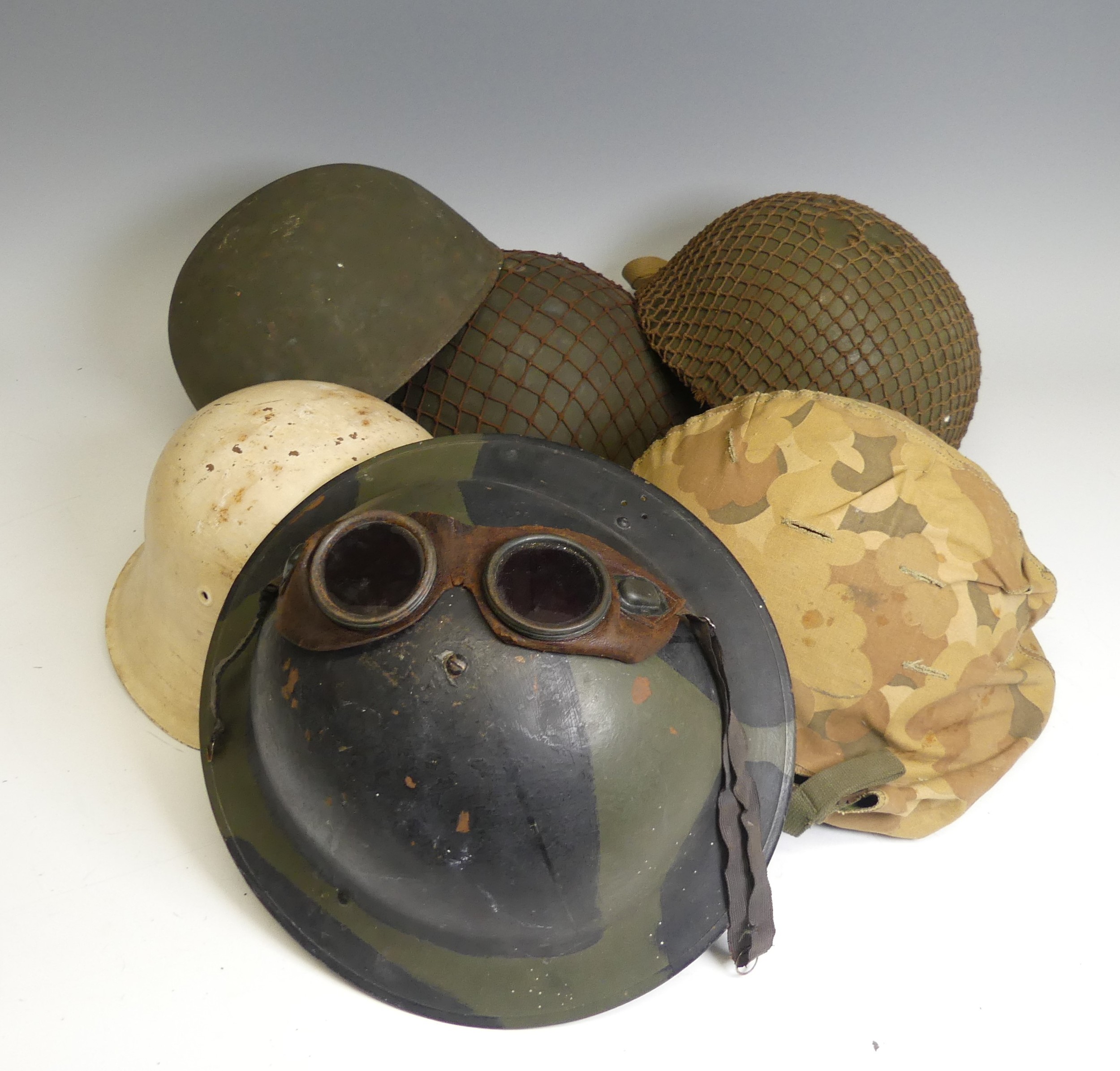 A group of six WW2 period and later military Helmets, including ;  A US 1970s helmet headband