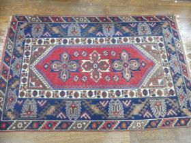 Tribal Rugs; a Turkish Rug, blue and red ground with all over geometric pattern set within a wide