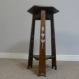 An Arts and Crafts oak hexagonal Plant Stand, raised on three pierced supports and triangular