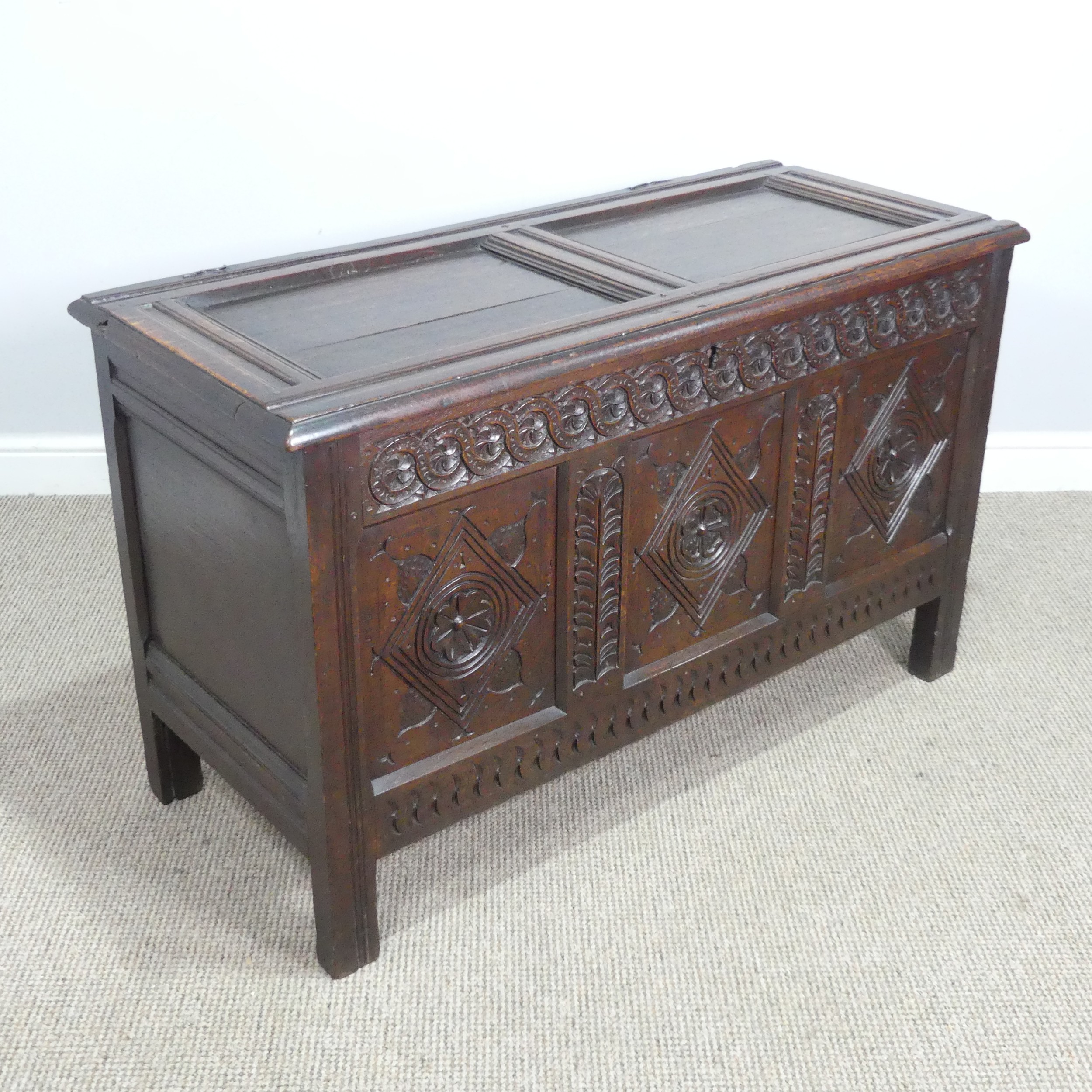 A 17th century oak Coffer, two panelled rectangular top with original pin hinges, over three