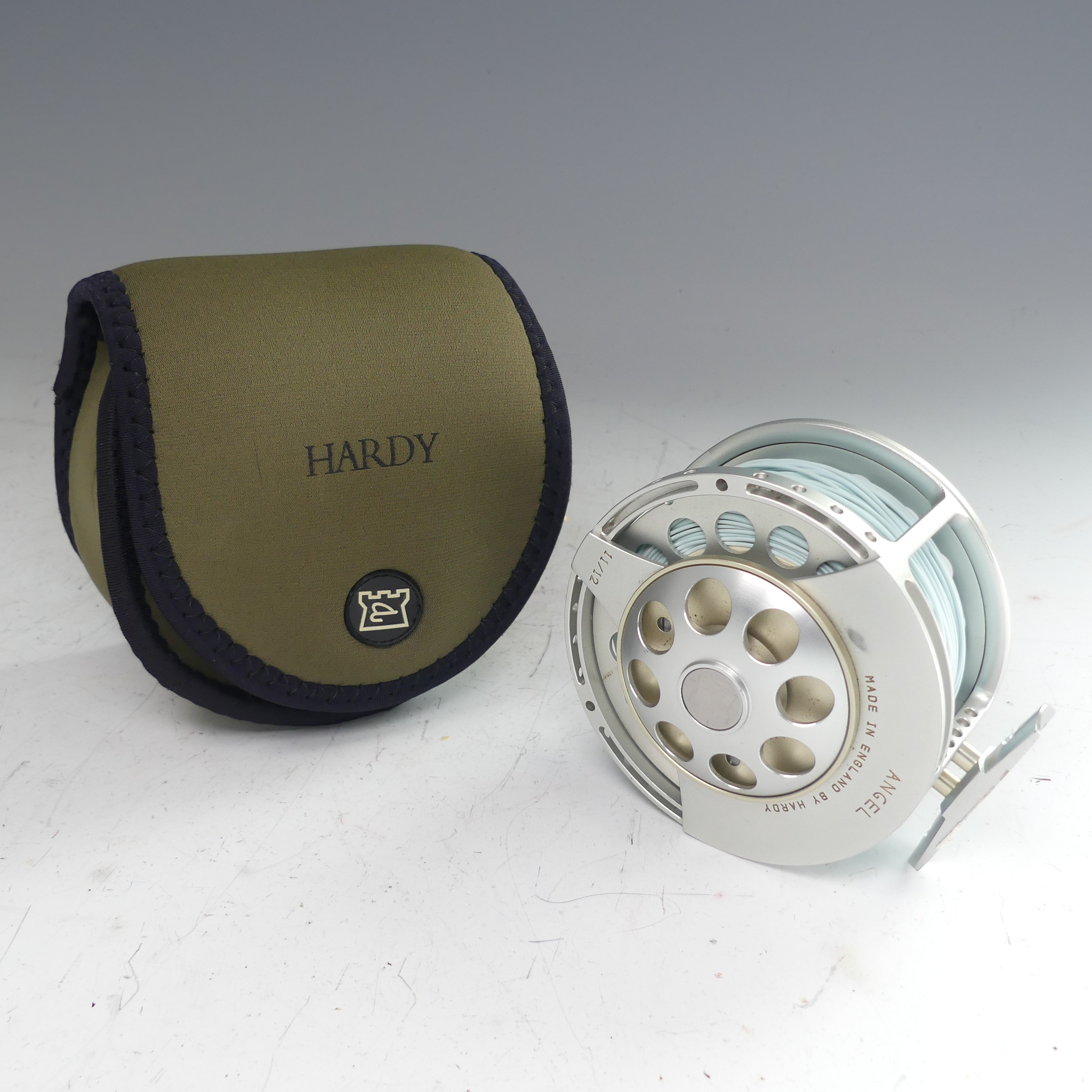 A Hardy Angel 11/12 fishing Reel, no. A26697, with Hardy pouch, 11.5cm diameter.