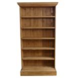 A large antique pine open Bookcase, moulded cornice over five deep shelves, raised on plinth base, W