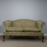 An antique George III style upholstered scroll end two-seater Sofa, raised on carved cabriole