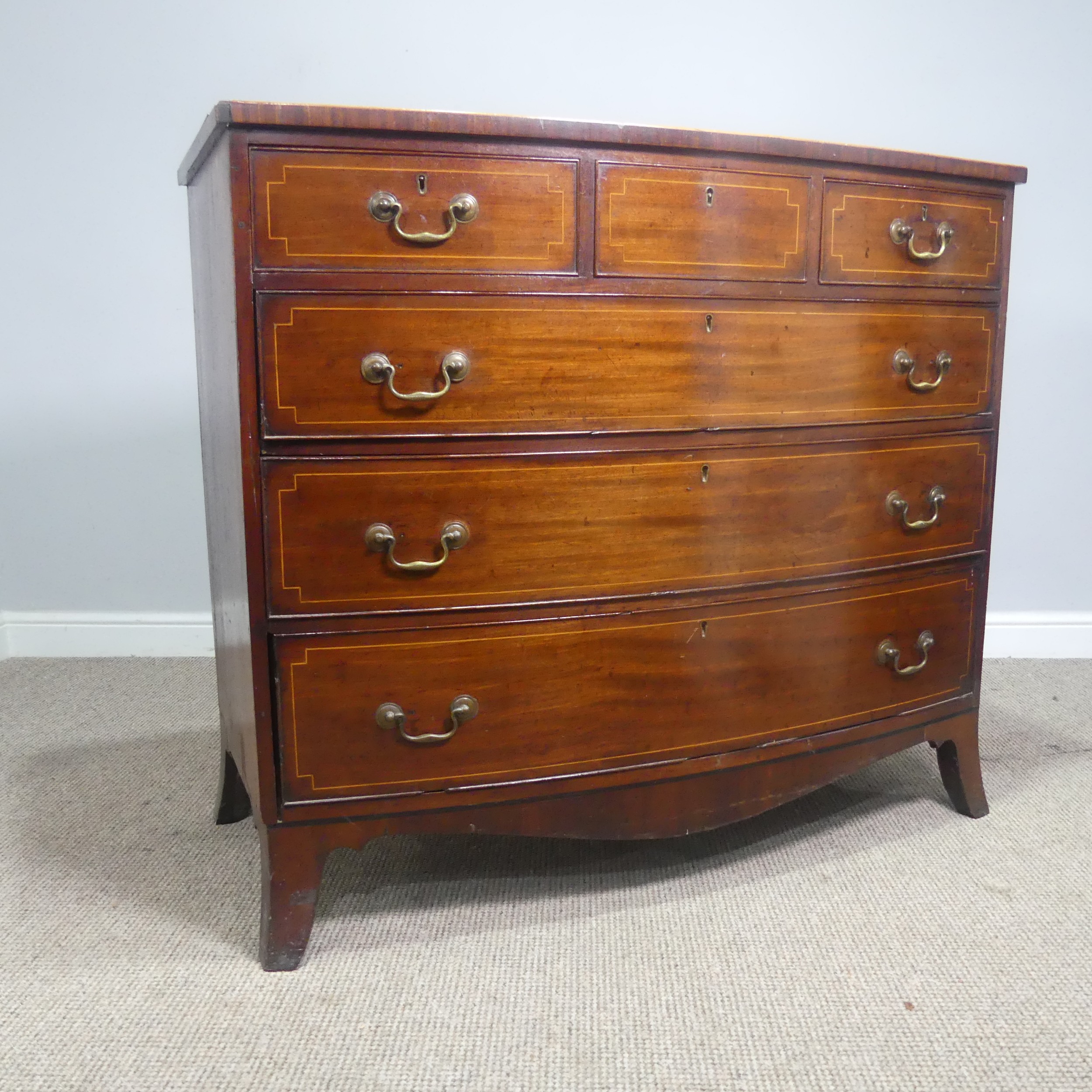 A Georgian mahogany bow-front Chest of drawers, three small drawers over three long graduating