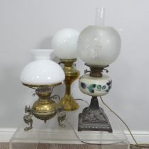 Three early 20thC oil lamps, now converted to electricity, together with two ceramic based table